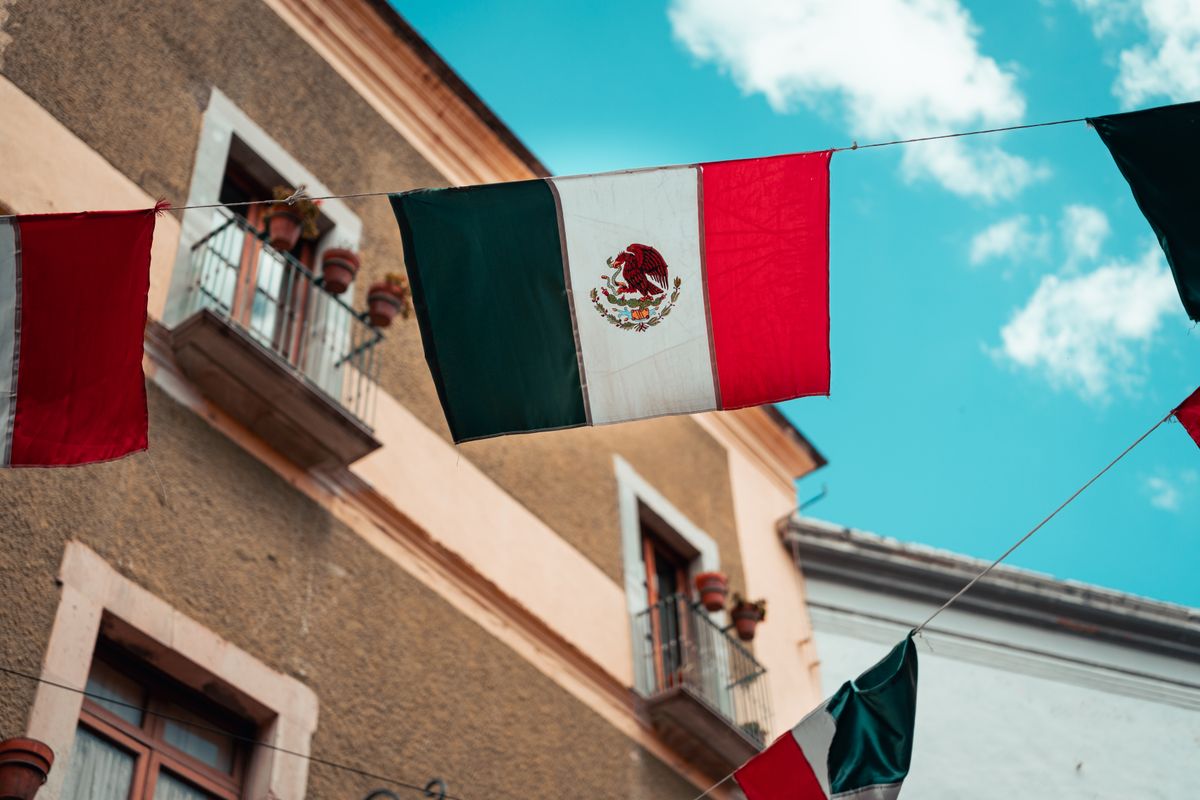 Mexican flag waving in front of an institutional building
