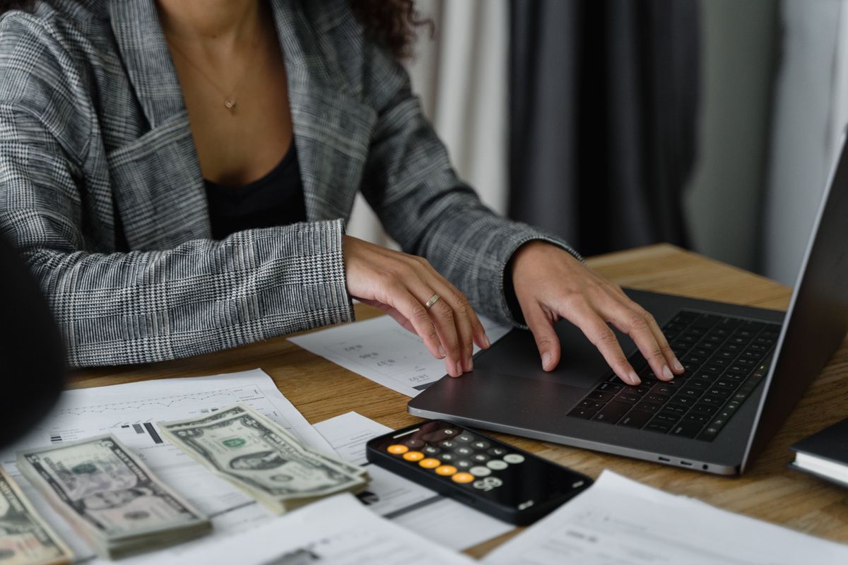 Professional planning their finances with laptop, calculator and documents